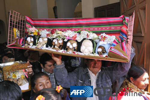 一个男子在骷髅节上带来自己精心装饰的亲人的头骨。图片来源：(AFP/国际在线) 